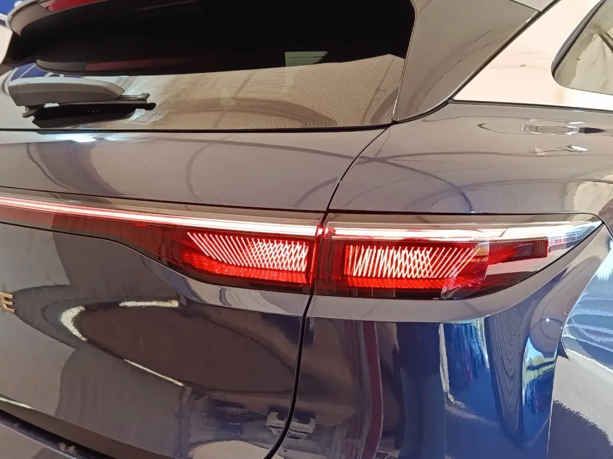 Feu arrière droit allumé sur Renault Mégane Techno EV60 bleu, vue rapprochée du côté arrière du véhicule.