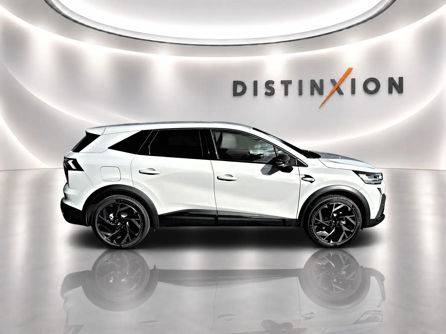 Vue latérale droite d'un Renault Symbioz gris rafale avec jantes noires et toit noir dans un showroom lumineux.