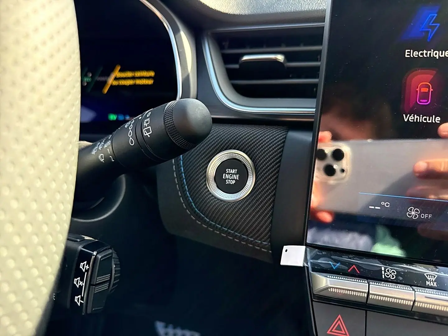 Vue rapprochée de l’intérieur côté gauche du Renault SYMBIOZ gris, avec bouton start engine stop et écran tactile.