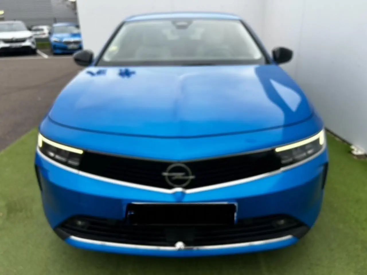 Vue frontale d'une Opel Astra bleu clair 2022 avec phares LED fins et calandre noire élégante.