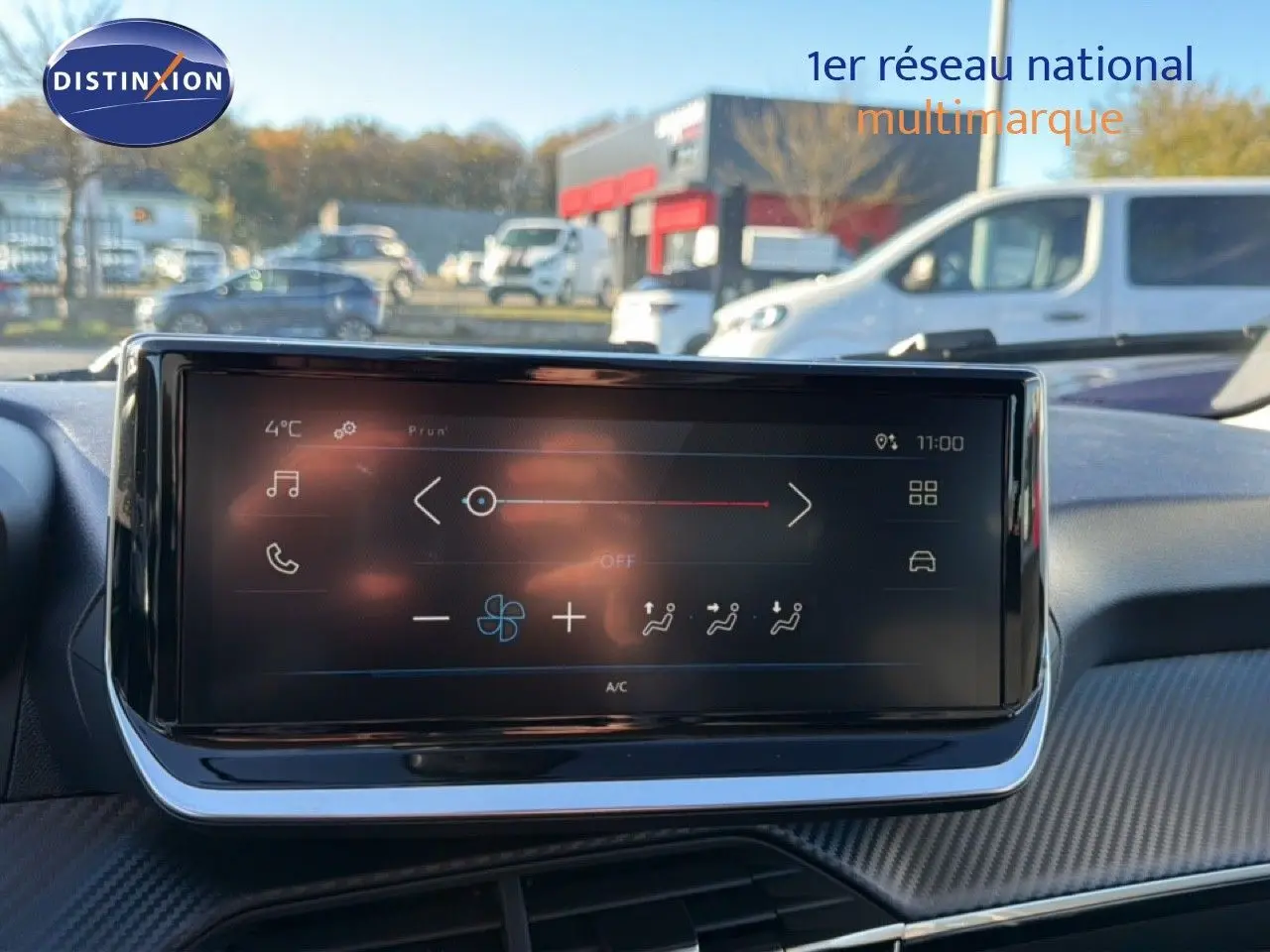 Écran tactile central du tableau de bord de la Peugeot 208 gris Artense, affichant les commandes de climatisation.