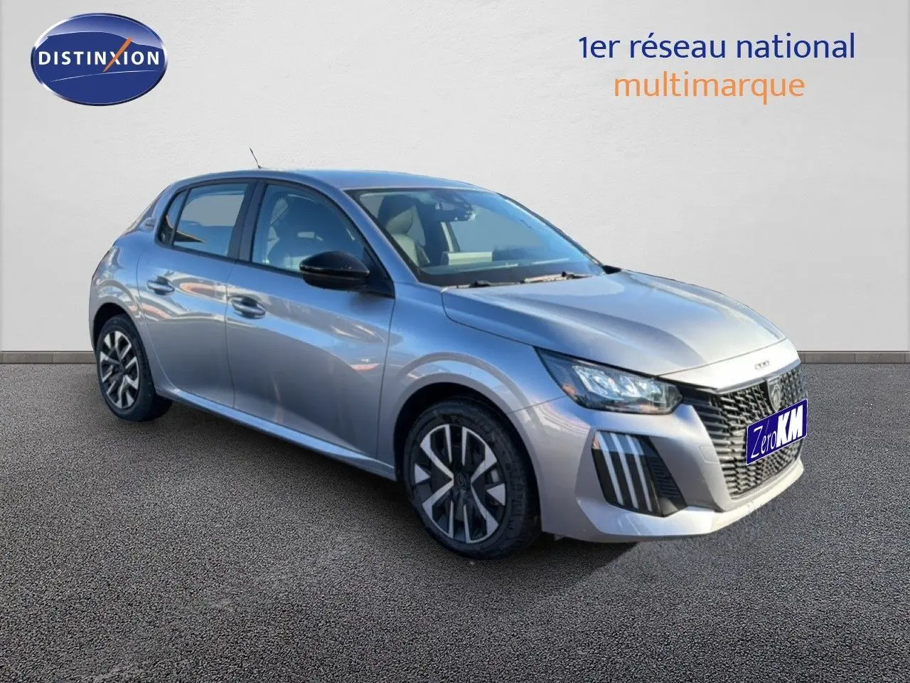 Peugeot 208 gris Artense métal vue 3/4 avant droit, avec calandre distinctive et feux LED modernes.