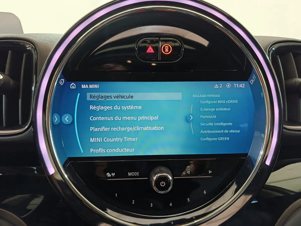 Écran tactile circulaire du tableau de bord du MINI Countryman blanc, affichant les réglages du véhicule.