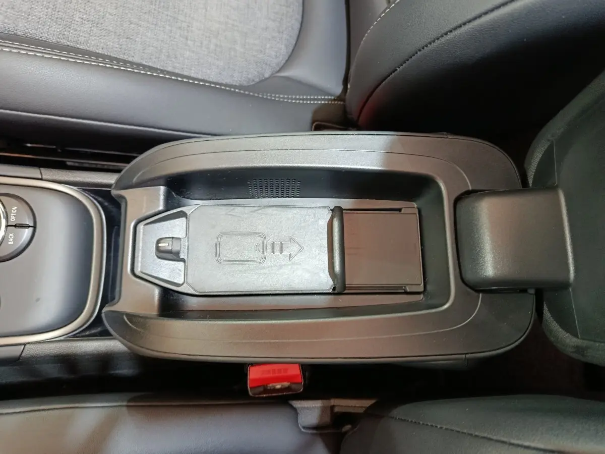 Vue plongeante sur la console centrale noire du MINI Countryman blanc, avec compartiment de rangement fermé.