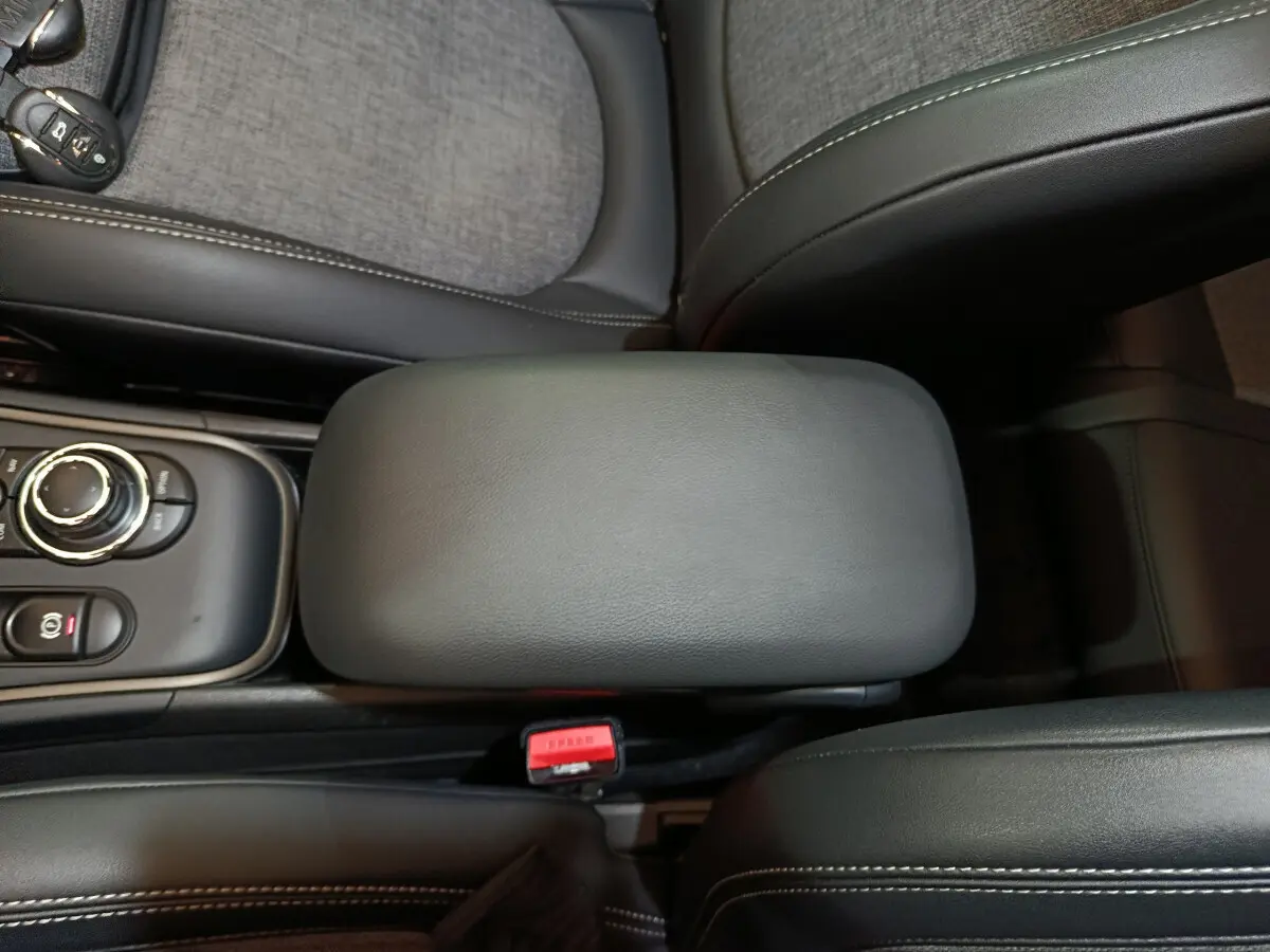 Vue plongeante sur l'accoudoir central noir et la console de la MINI Countryman Cooper SE hybride rechargeable 2021.