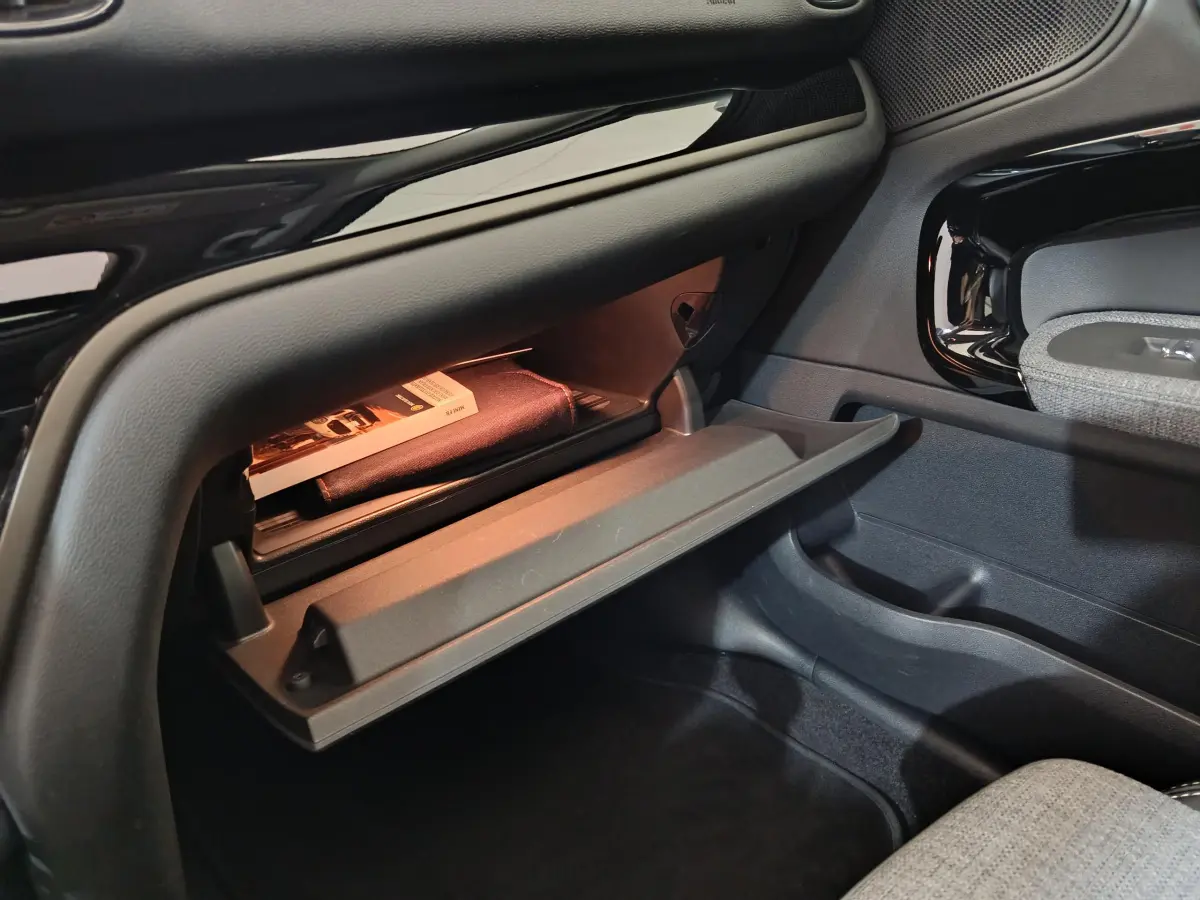 Gant de boîte à gants ouvert côté passager du MINI Countryman blanc, montrant un manuel et un éclairage intérieur.