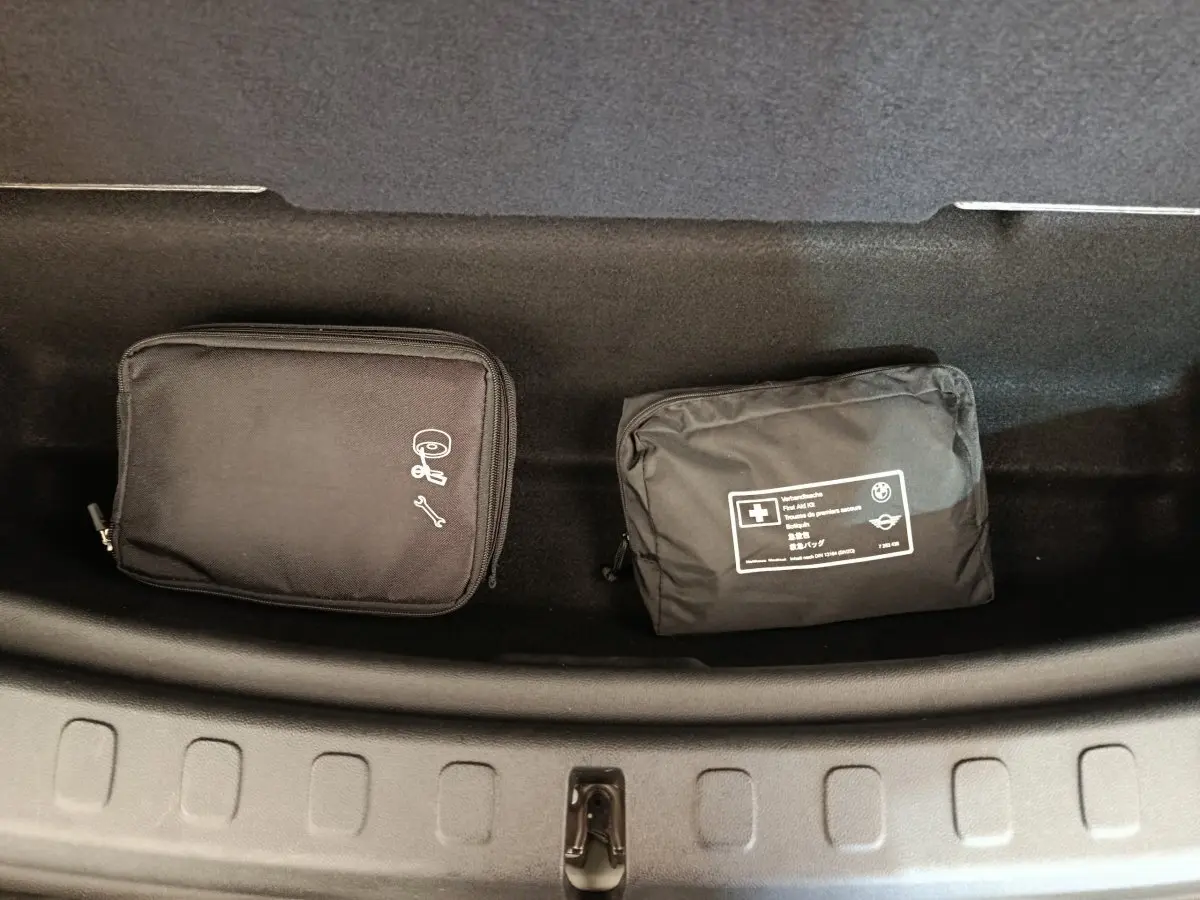 Vue plongeante sur le coffre du MINI Countryman blanc, montrant deux trousses de secours noires rangées.