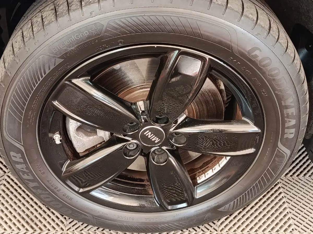 Gros plan sur la jante noire brillante et le pneu Goodyear d'un MINI Countryman blanc hybride rechargeable.