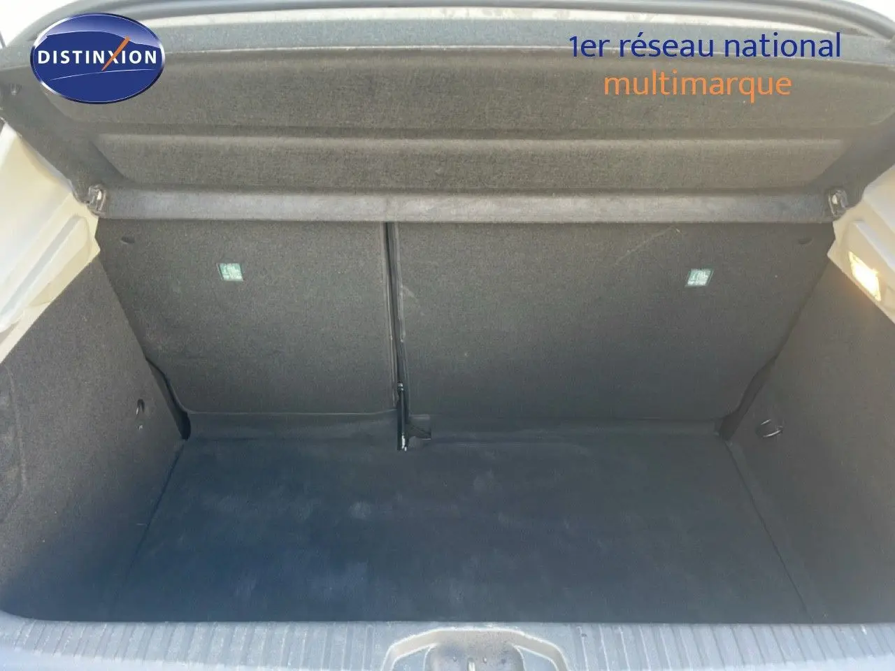 Coffre ouvert d'une Renault Clio blanc glacier 2020, vue intérieure montrant l'espace de chargement vide et propre.