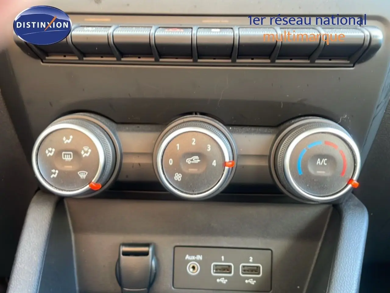 Commandes de climatisation manuelle avec trois molettes et ports USB sur Renault Clio blanc glacier 2020.