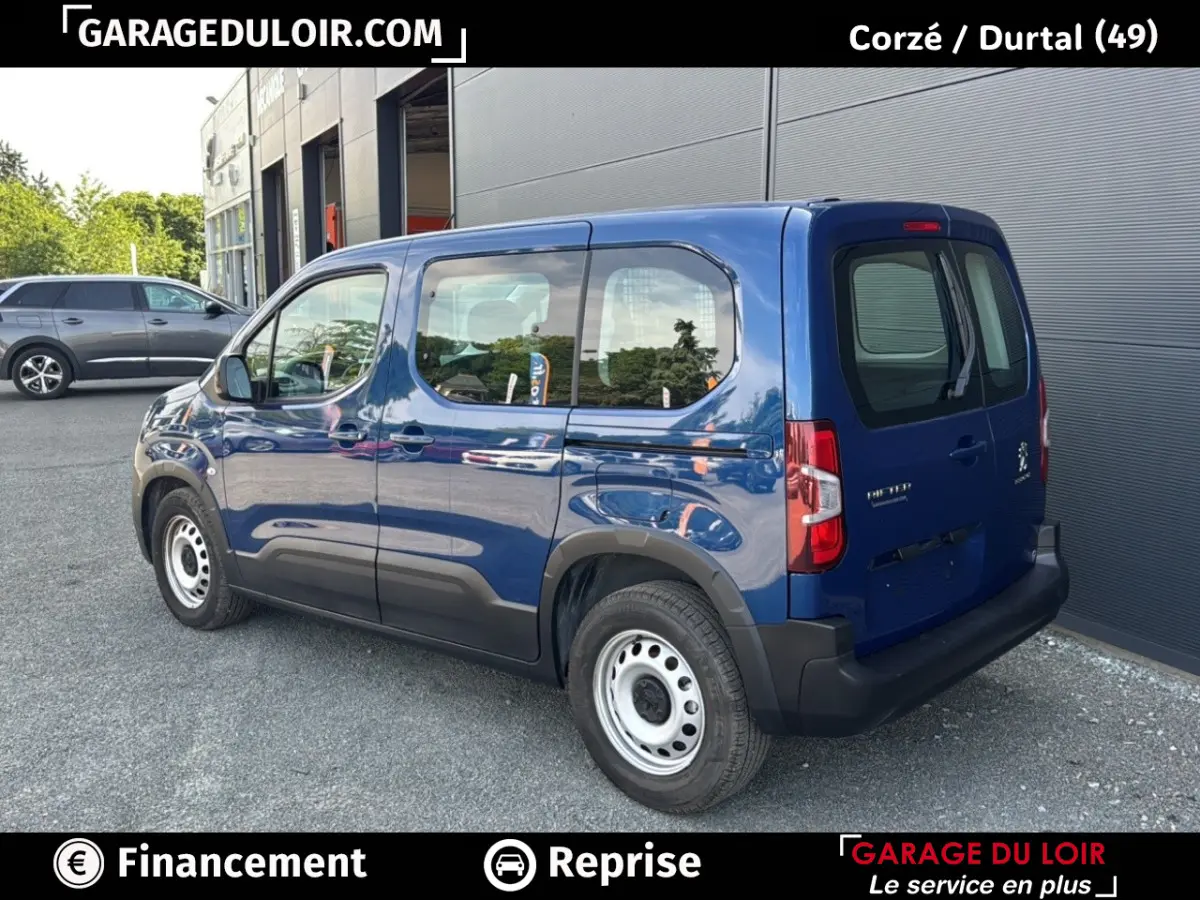 Vue 3/4 arrière droite d’un Peugeot Rifter bleu 2024 avec jantes acier et détails noirs sur les bas de caisse.