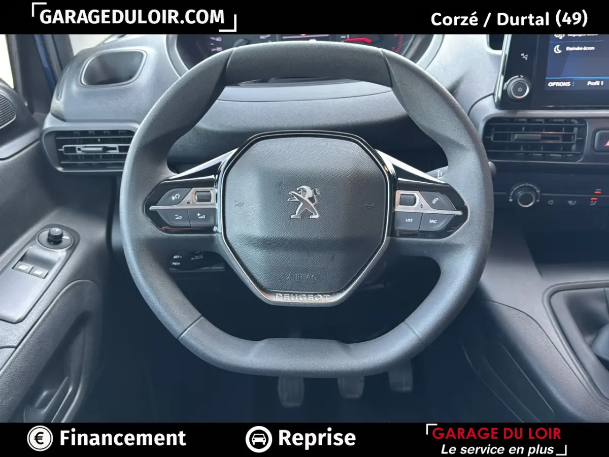 Vue rapprochée du volant multifonction noir du Peugeot Rifter 2024 avec tableau de bord et commandes visibles.