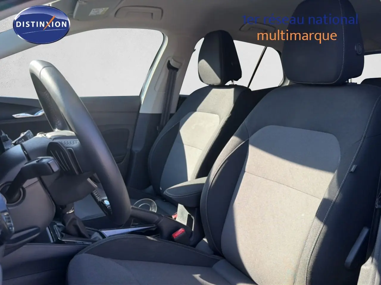 Vue intérieure côté gauche de la Skoda Fabia 2025, sièges tissu noir et gris avec volant cuir multifonction.