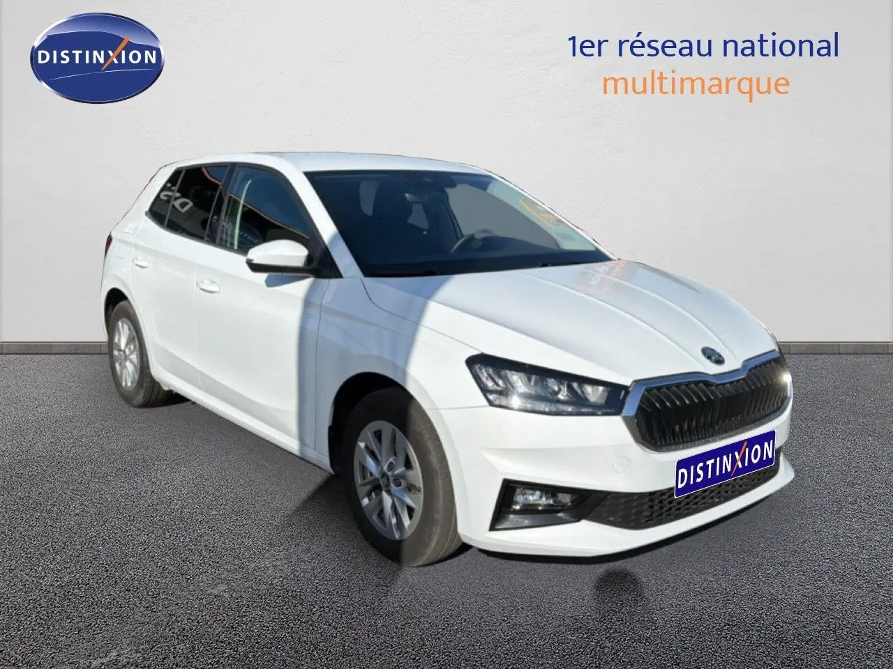Vue 3/4 avant droite d'une Skoda Fabia blanche glacier avec calandre noire et jantes alliage.