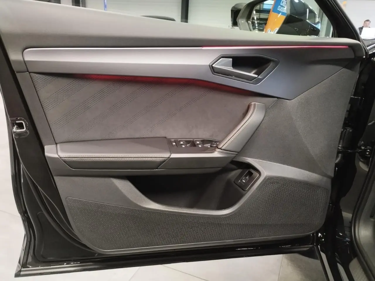 Vue rapprochée de la contre-porte côté gauche noire avec surpiqûres et bande lumineuse rouge du CUPRA Formentor 2026.