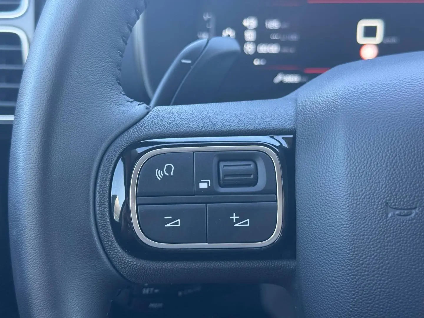 Gros plan sur les commandes gauche du volant cuir noir du Citroën C5 Aircross 2025, avec boutons multifonctions.