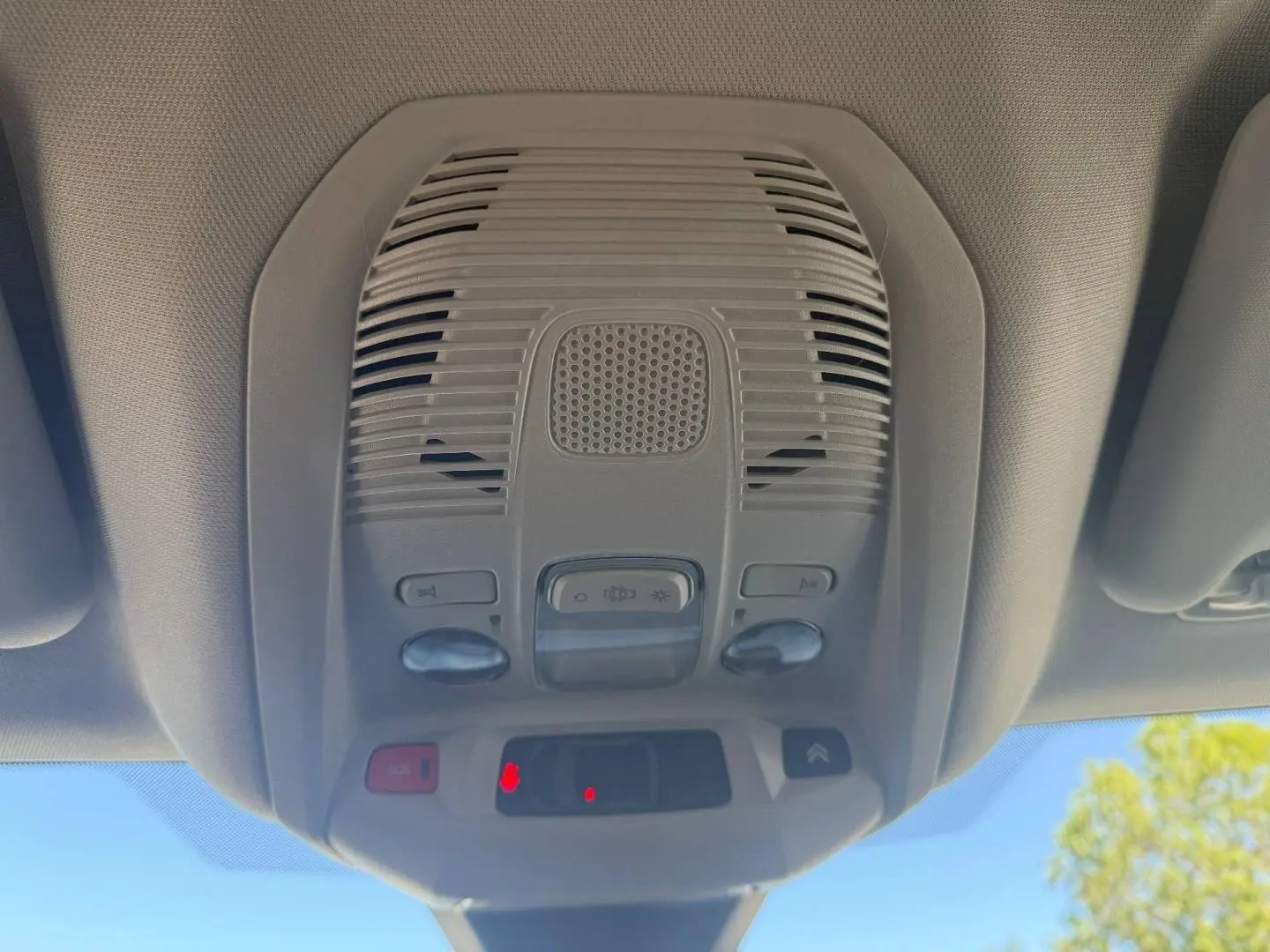 Vue intérieure en contre-plongée du plafonnier gris clair avec commandes et bouton SOS du Citroën C5 Aircross 2025.