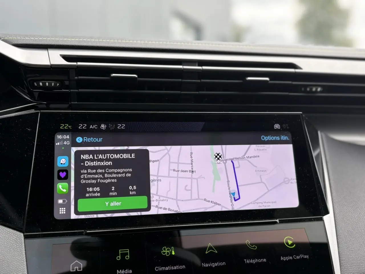Écran tactile central 10 pouces du Peugeot 308 GT 2024 affichant la navigation GPS avec interface Apple CarPlay.