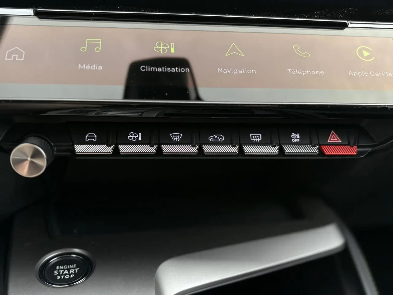 Gros plan sur la console centrale de la Peugeot 308 GT 2024 avec boutons tactiles et écran tactile lumineux.