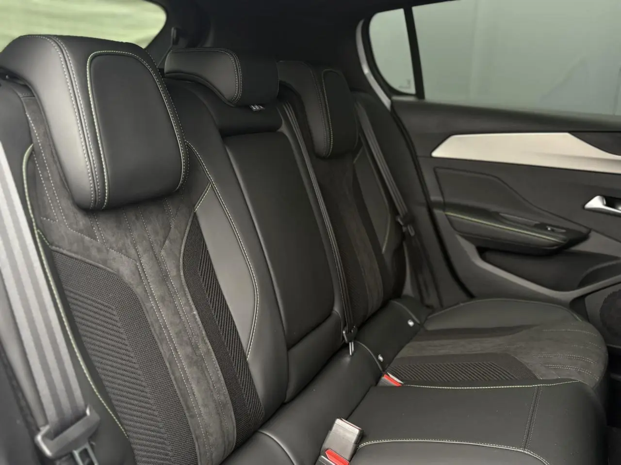 Vue côté droit des sièges arrière en sellerie tri matières noire avec surpiqûres contrastantes de la Peugeot 308 2024.