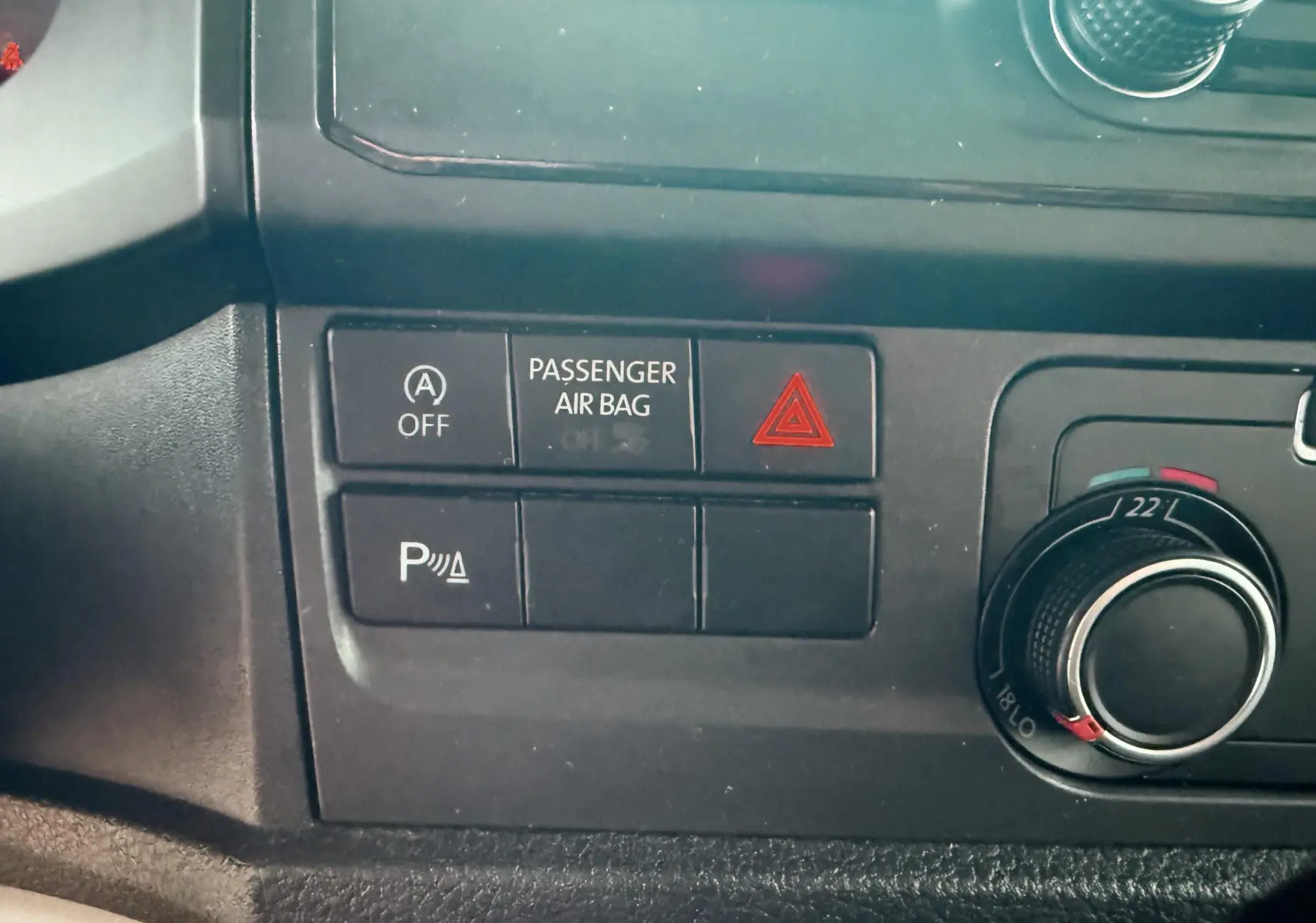 Détail du tableau de bord du Volkswagen Transporter L1H1 2018 montrant les boutons de sécurité et la commande de climatisation.