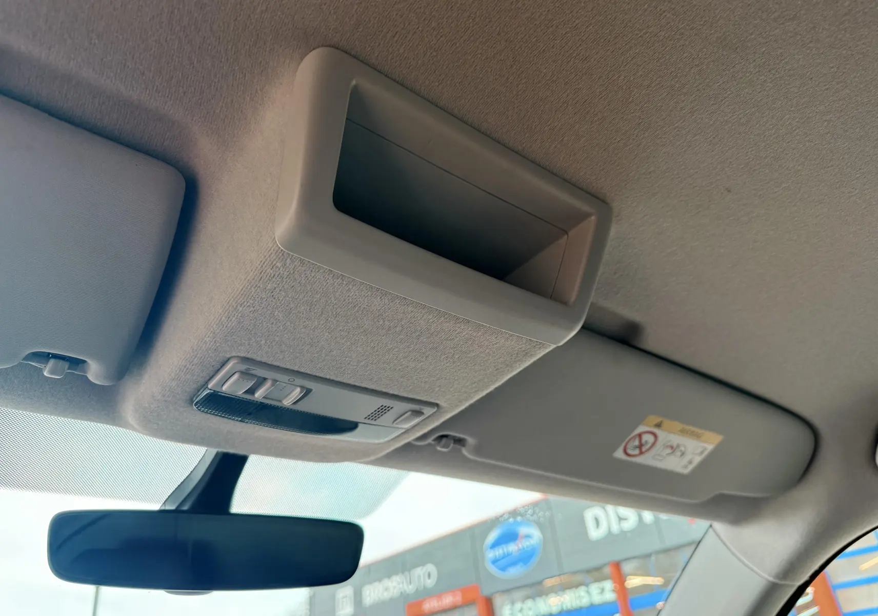 Vue intérieure du plafond avant du Volkswagen Transporter blanc 2018, montrant le pare-soleil, le rétroviseur et la console de plafonnier.