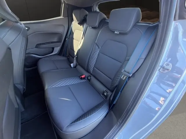 Vue intérieure arrière droite sur la banquette noire avec surpiqûres bleues de la Renault Clio Esprit Alpine E-Tech gris clair 2025.