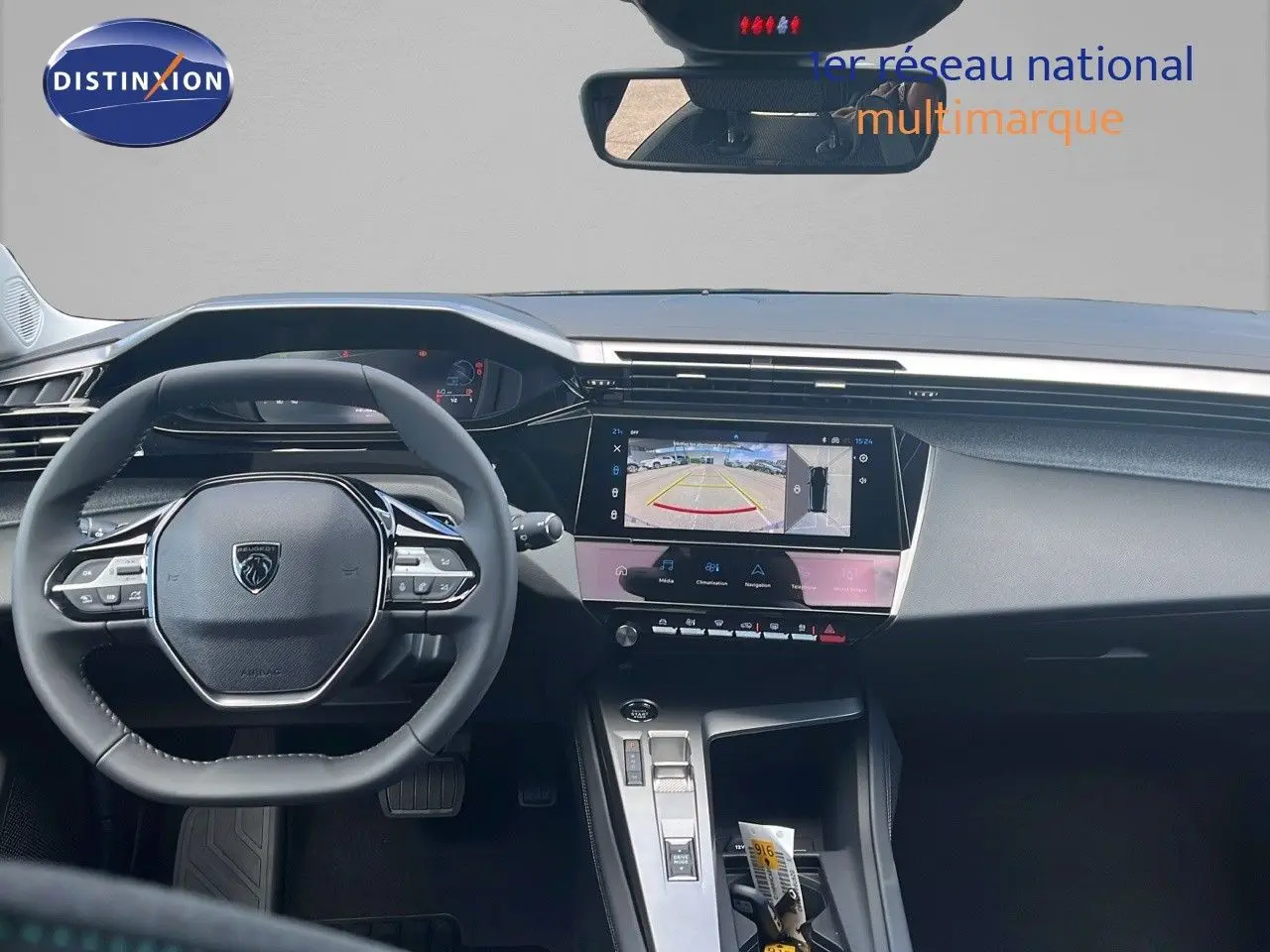 Vue intérieure du tableau de bord de la Peugeot 308 hybride 2024, avec écran tactile affichant la caméra de recul.
