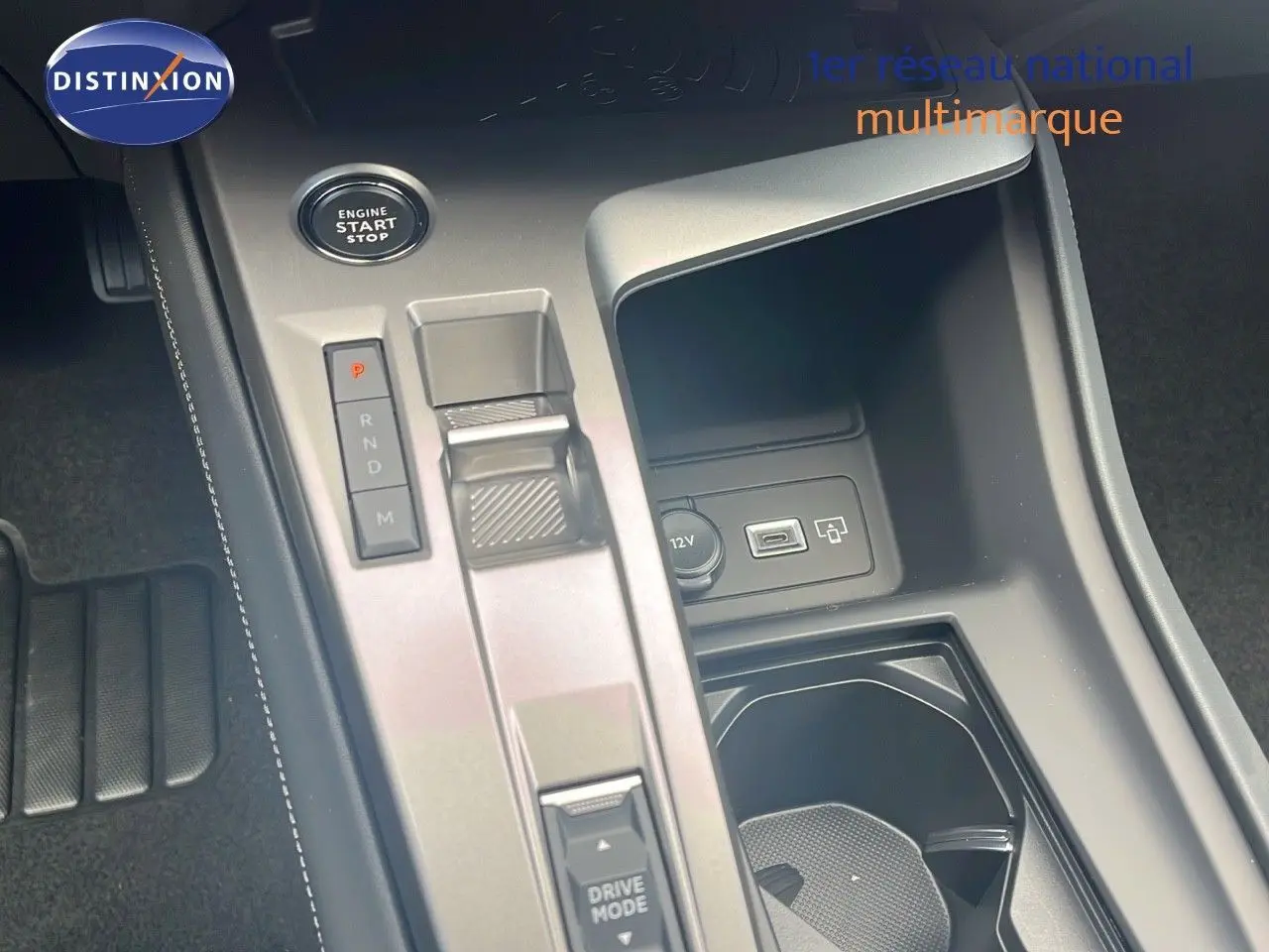 Console centrale de la Peugeot 308 hybride 2024 montrant la commande de boîte automatique et prise USB en intérieur noir.