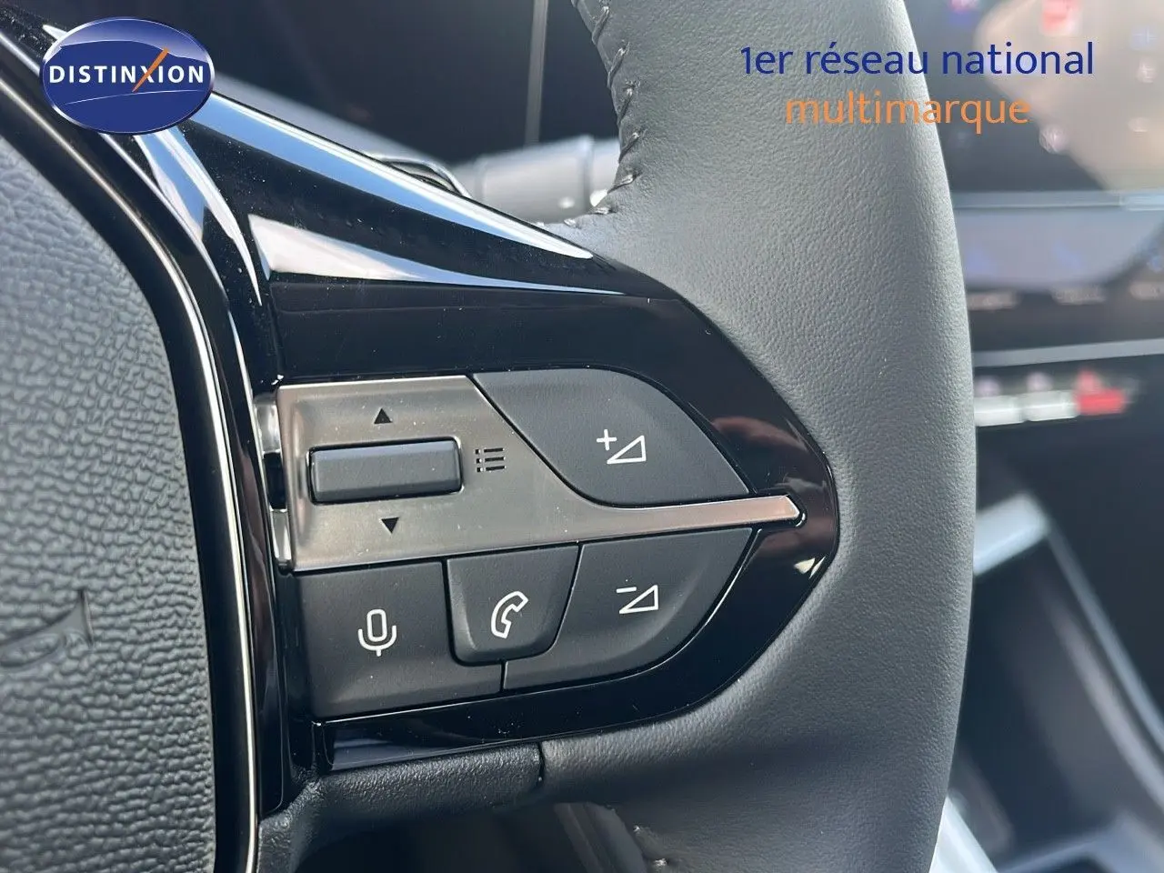 Gros plan sur les commandes au volant en cuir noir de la Peugeot 308 hybride 2024, avec boutons de volume et appel.