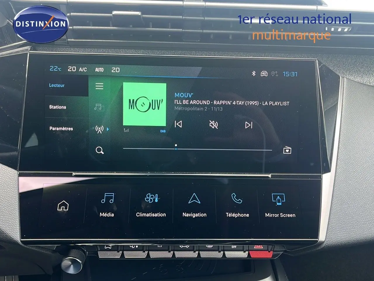 Écran tactile central de la Peugeot 308 hybride 2024 affichant la radio et les options multimédia dans un intérieur moderne.