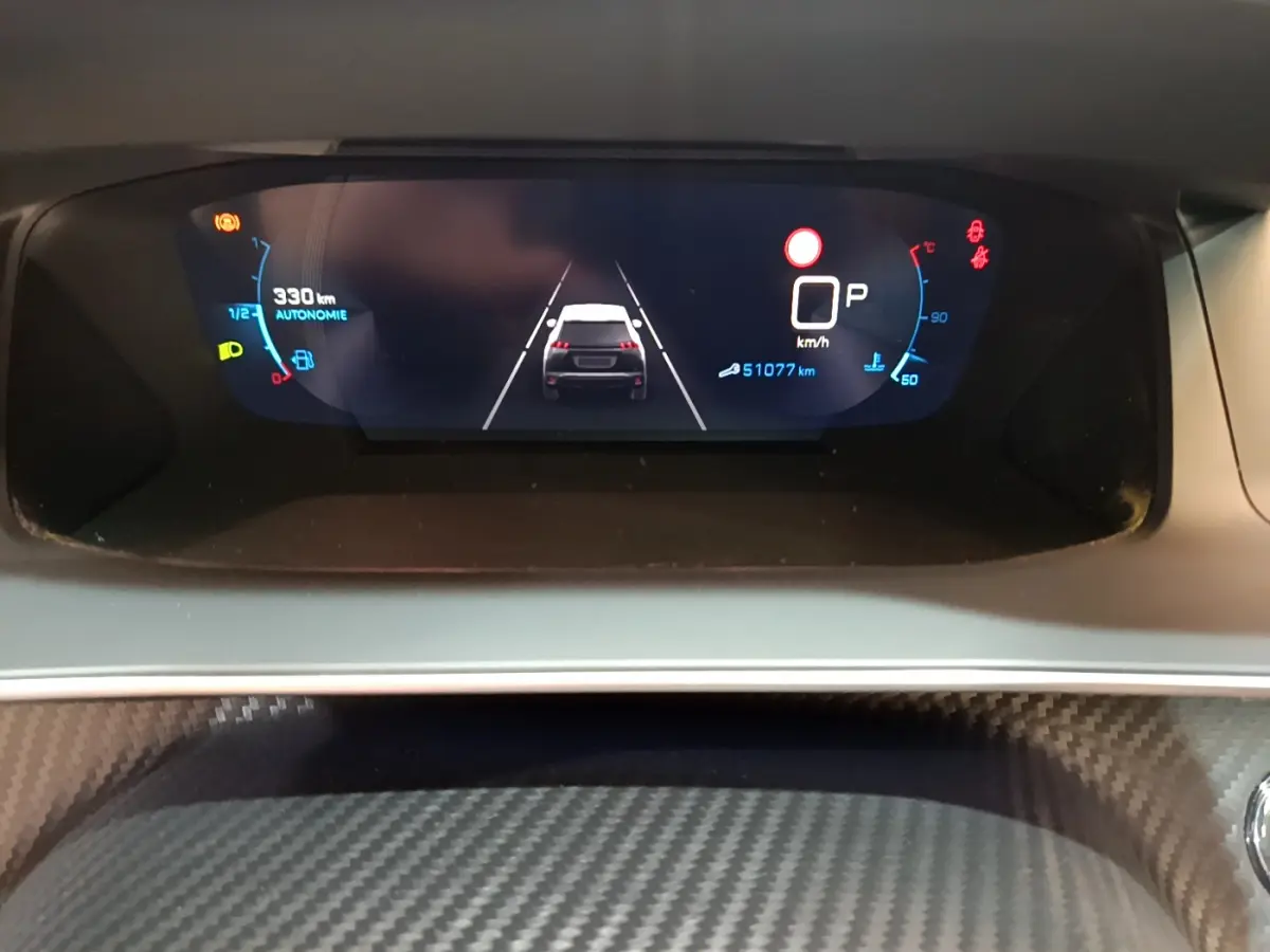 Affichage numérique du tableau de bord du Peugeot 2008 gris clair, montrant la vitesse, autonomie et assistance au maintien de voie.