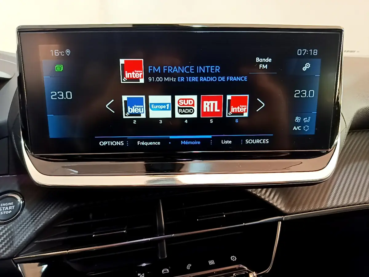 Écran tactile 10 pouces du tableau de bord du Peugeot 2008 gris clair, affichant les stations radio FM.