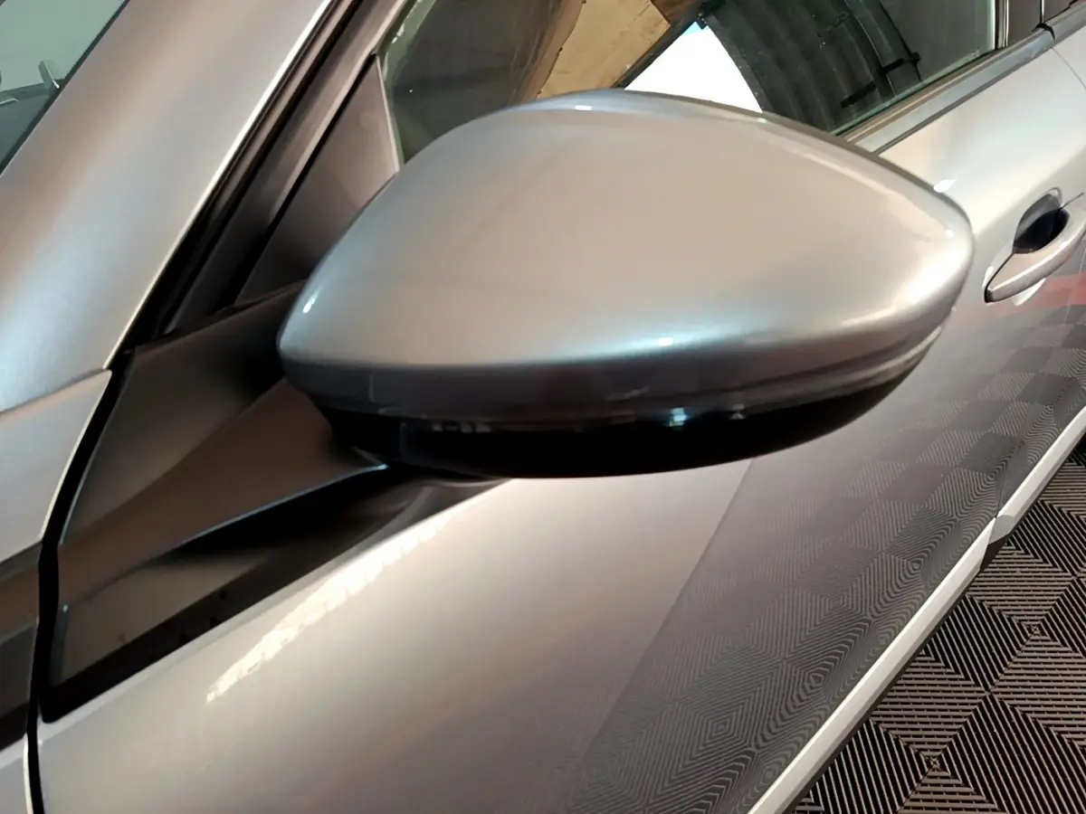 Rétroviseur côté gauche gris clair du Peugeot 2008 PureTech 130, avec poignée de porte visible en arrière-plan.