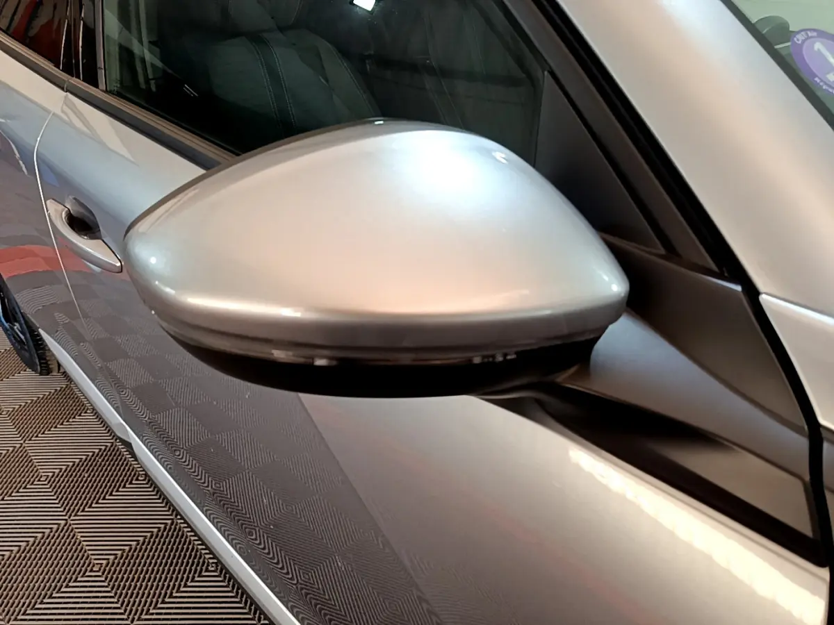 Rétroviseur côté gauche gris clair du Peugeot 2008 PureTech 130, vue rapprochée sur la portière et la vitre.