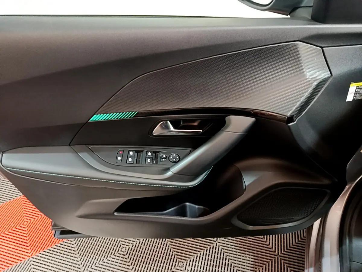 Vue rapprochée de la porte côté conducteur gris clair du Peugeot 2008 avec insert décoratif et commandes électriques.