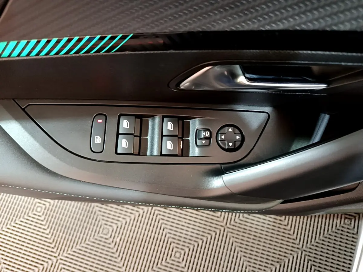Vue rapprochée du panneau de commandes des vitres côté conducteur d'une Peugeot 2008 gris clair, avec poignée chromée.
