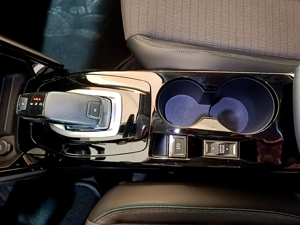 Vue rapprochée de la console centrale noire brillante avec levier de vitesse automatique et porte-gobelets du Peugeot 2008 gris clair.