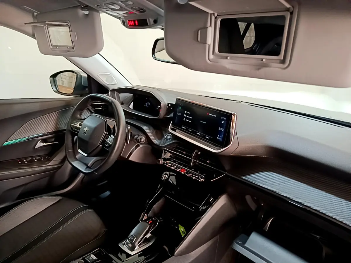 Intérieur Peugeot 2008 gris clair, vue côté conducteur sur tableau de bord et écran tactile central lumineux.