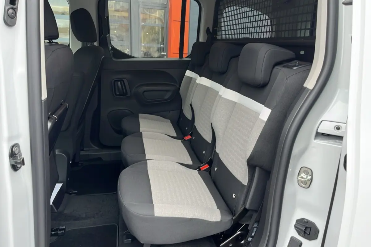 Vue latérale intérieure du Citroën Berlingo Kaolin white 2026 montrant les trois sièges arrière indépendants en tissu bicolore.