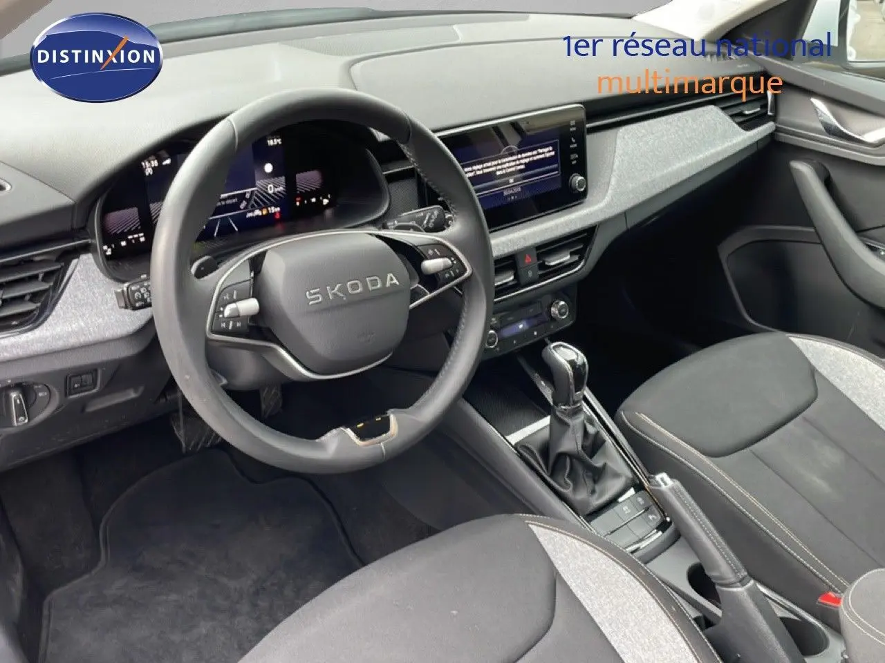 Vue intérieure côté conducteur du Skoda Kamiq 2025, volant multifonction et tableau de bord numérique en noir et gris.