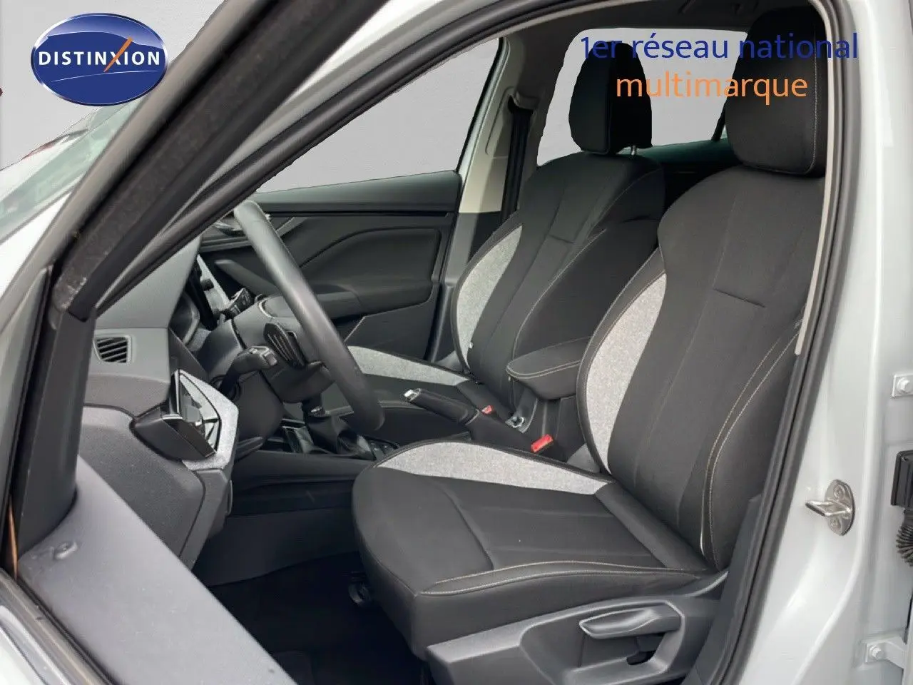 Vue intérieure côté conducteur du Skoda Kamiq blanc glacier 2025, sièges tissu bicolore noir et gris.