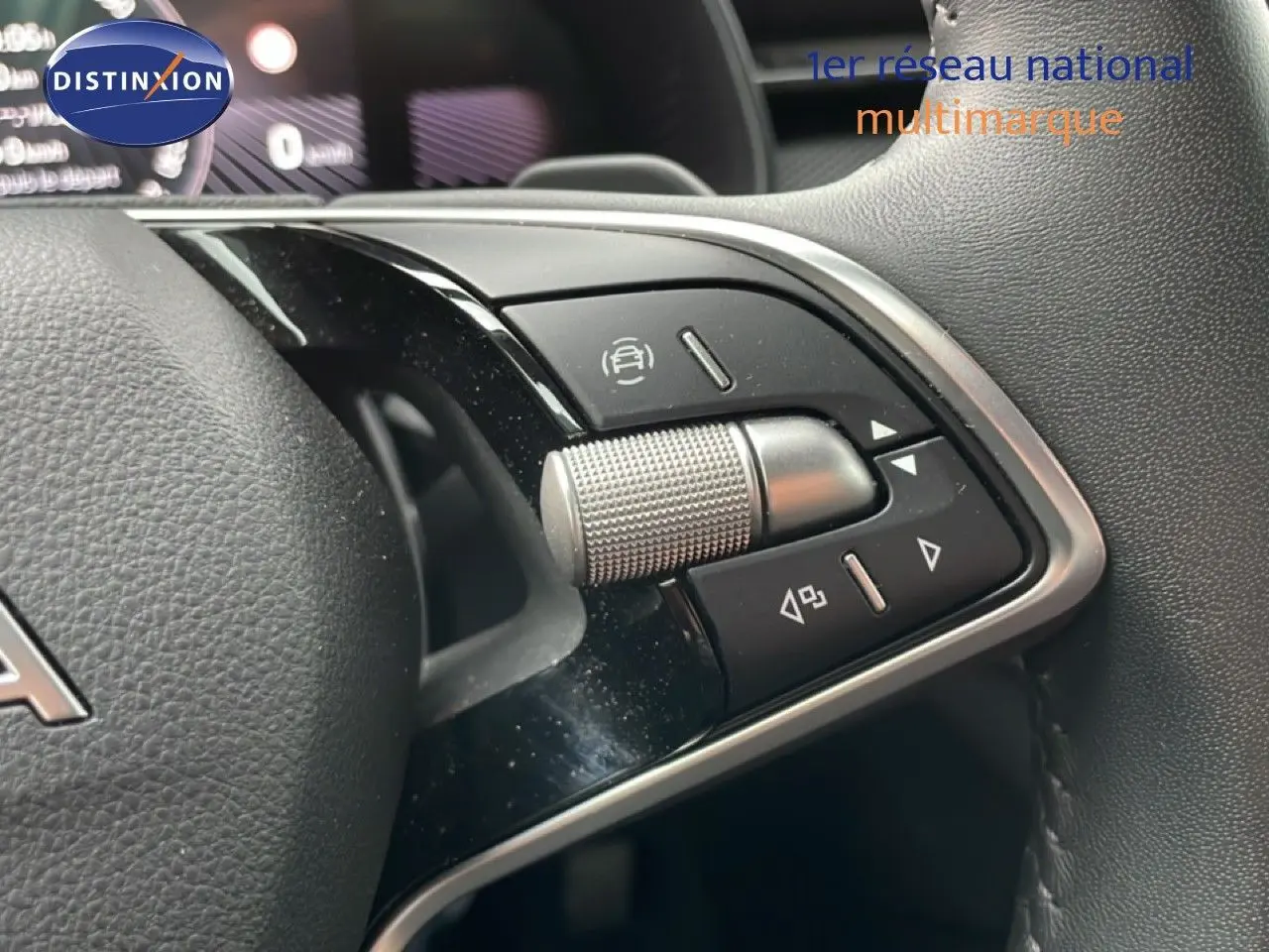 Gros plan sur les commandes multifonctions au volant noir du Skoda Kamiq 2025, avec molette argentée et boutons tactiles.