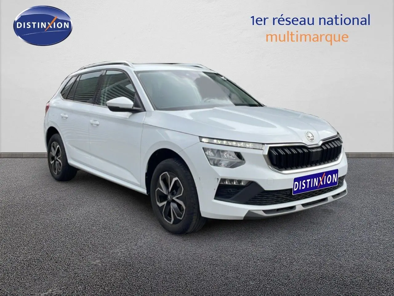 SUV Skoda Kamiq blanc glacier vu en 3/4 avant droit avec calandre noire et jantes distinctives.