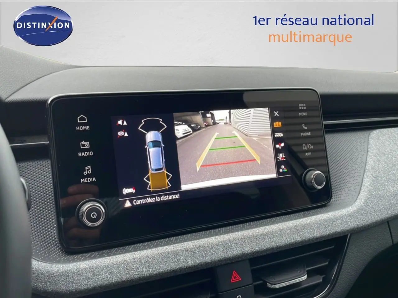 Écran central du Skoda Kamiq blanc glacier 2025 montrant la caméra de recul avec guidage de trajectoire.