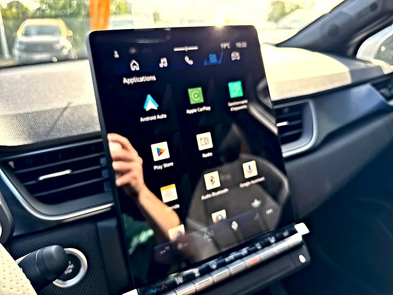 Écran tactile central affichant les applications, intérieur noir du Renault Symbioz gris rafale, vue de face côté conducteur.