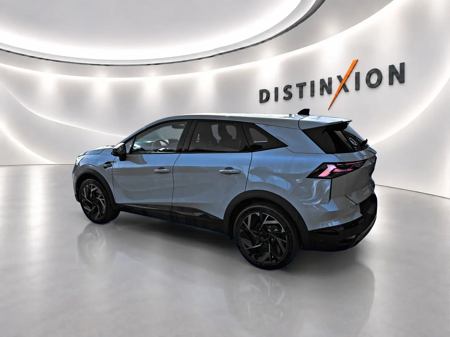 Renault Symbioz gris rafale en vue 3/4 arrière droit, avec jantes noires et feux arrière LED distinctifs.