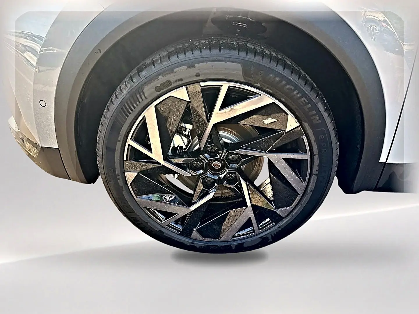Gros plan sur la roue avant droite avec jante alu noire et argent du Renault Symbioz gris rafale.