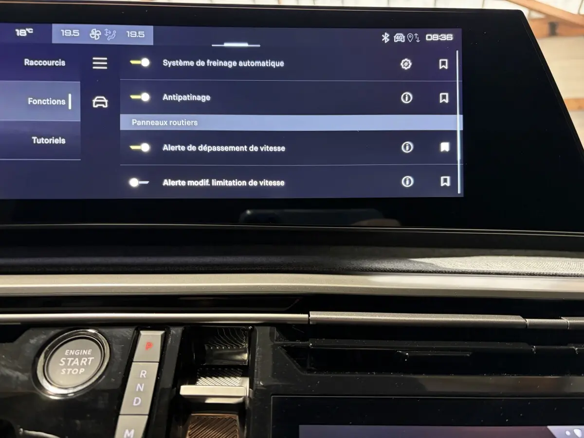 Vue rapprochée de la console centrale du Peugeot 3008 blanc, avec écran tactile et bouton démarrage visible.