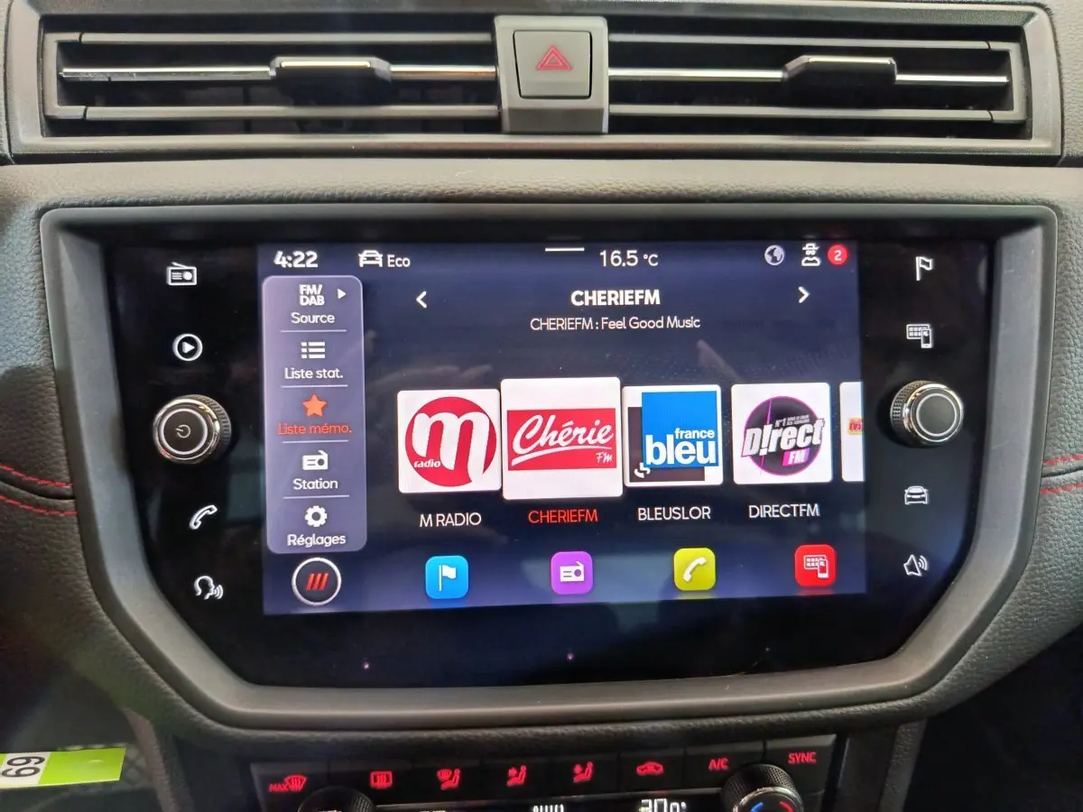 Écran tactile central du tableau de bord du SEAT Arona 2021 avec interface radio et commandes climatisation visibles.